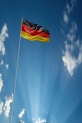 Waving National flag of Germany on flagpole in sky