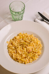 Pasta e patate con provola tradizionale napoletana guarnita con granella di pistacchio servita in un ristorante elegante 