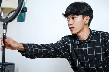 Young Asian Man As Content Creator Adjusting Ring Light Preparing For His Live Stream