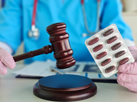 Legal and medical themes intersect with gavel and pill pack
