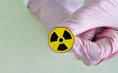 Handling hazardous materials with safety gloves focusing on radiation symbol