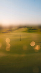 Minimalist abstract, sunrise, golf, fairway, amber light, soft green, gentle haze, dreamy, bokeh, no people, text, or logos