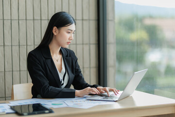 rofessional female employee seriously analyzing data on her computer.