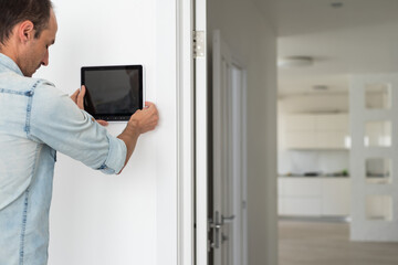 man watching delivery man on security camera cctv video on tablet