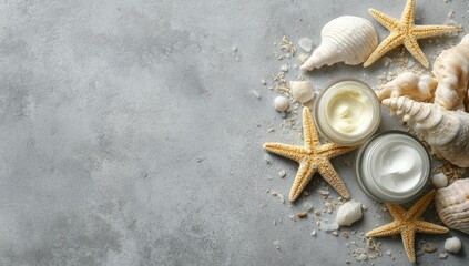 Light cream jars atop a gray stone surface surrounded by seashells and starfish