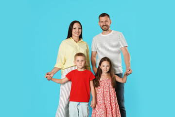 Portrait of happy family on light blue background