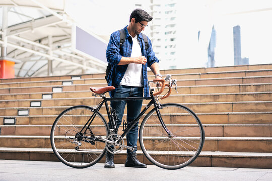 Smart businessman ride bicycle in downtown. Environmentalist commuting by cycling reduce carbon footprint global warming. Bike to work eco friendly alternative transportation green energy vehicle - Powered by Adobe