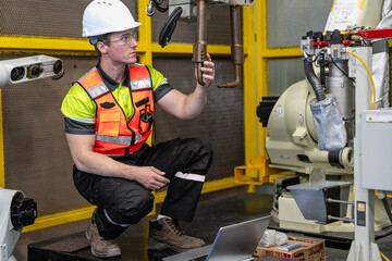 Fototapeta premium Smart Caucasian engineer work setup AI automated in robotics electronics engineering laboratory. Technician inspector maintenance repair check robot arm machine in artificial intelligent laboratory.