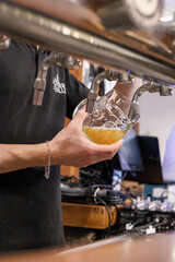 bartender pouring beer into a beer glass
