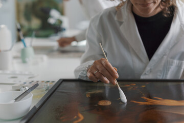 Professional painting conservator restoring a Caravaggio painting