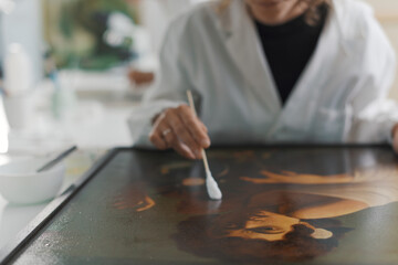 Professional painting conservator restoring a Caravaggio painting