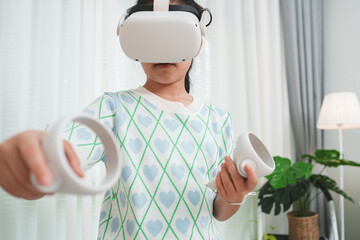 Young girl using a VR headset and controllers for immersive learning at home.