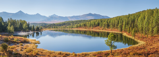 Mountain lake on an autumn morning, sunny weather, forest shores, panoramic view