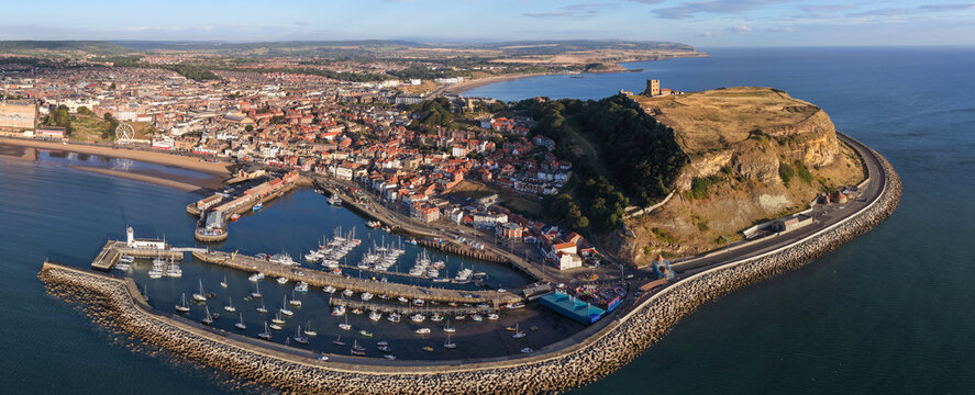 Aerial panorama of Scarborough UK in the morning sunlight, showing the sandy beach and seafront promenade. 