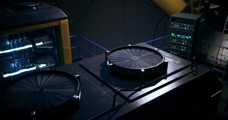 Large cooling fans and advanced technology are utilized in a dimly lit industrial setting. The intricate machinery maintains optimal temperatures for performance and efficiency.