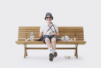Rude and boorish tourist sitting on a bench full of garbage.