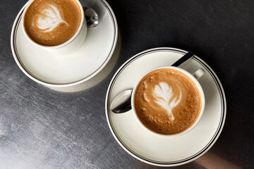 Flat White Coffee with Latte Art Served for Two on Metal Cafe Table. Cafe Still Life.