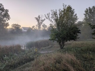 Early autumn morning with fog on the field and on the river