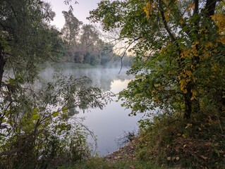 Early autumn morning with fog on the field and on the river