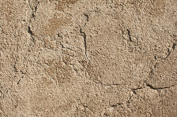 brown background, photo shows texture of old concrete plastered wall with cracks