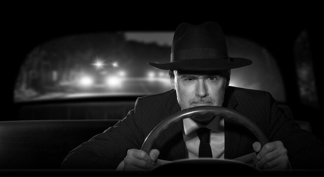 Criminal man with a hat, escaping from the police at night while driving his car. 1950s film noir style.