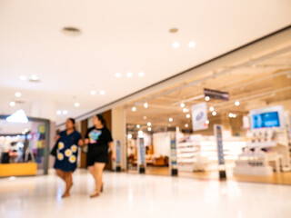 Blurred Couple Walking Hand in Hand Through Modern Shopping Mall with Shopping Bags
