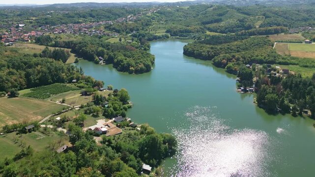 Drone shot of a beautiful lake surrounded by modern cottages and a village