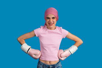 Young woman wearing pink boxing gloves and headscarf fighting cancer