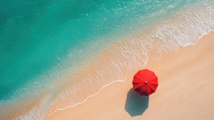Obraz premium Red beach umbrella on serene sandy beach during daytime