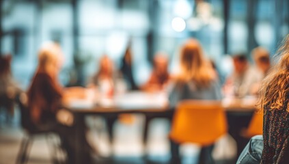 Blurred view of a group of people seated around a table in a modern space