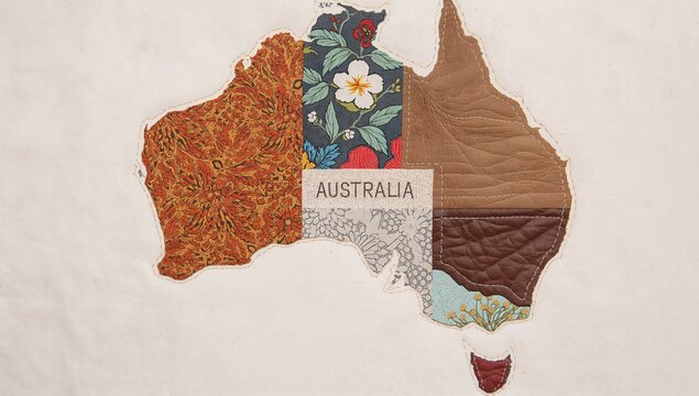 Displaying patchwork map of Australia on cream cloth background, with central label patch - Powered by Adobe