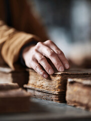 Hand rests on an antique book. Symbol of knowledge, history, and wisdom. Ideal for literature, education, libraries, heritage, or historical project themes.