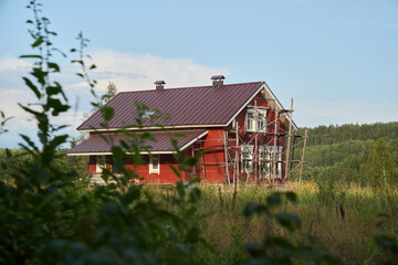 Obraz premium Charming Red House Elegantly Surrounded by Beautiful, Lush Greenery and Natures Splendor