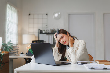 Stressed businesswoman suffering neck pain working from home office
