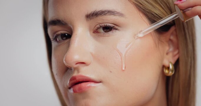 Beauty, skincare and serum with portrait of woman in studio for self care, peptide benefit and cosmetics glow. Collagen, shine and dermatology with person and dropper on white background for facial
