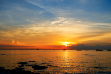 sunset in the sea. Beautiful colorful sky and cloud in twilight time background. Orange fluffy clouds and sun sunlight reflection in the blue sky.