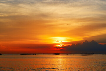 sunset in the sea. Beautiful colorful sky and cloud in twilight time background. Orange fluffy clouds and sun sunlight reflection in the blue sky.