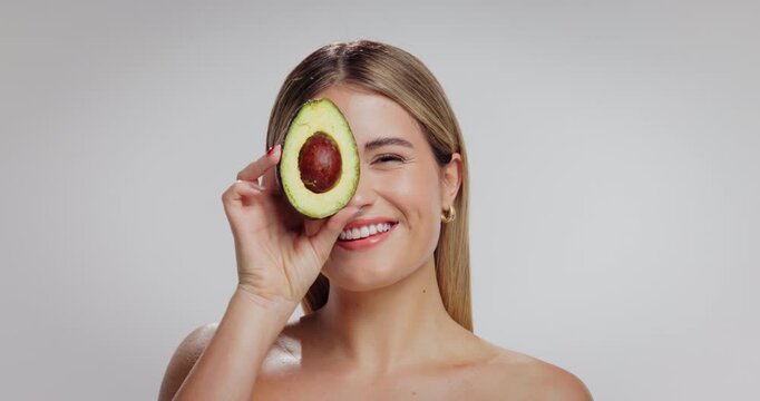 Beauty, avocado and face of woman in studio with skincare, natural and moisturizing benefits for health. Mockup space, portrait and person with fruit for glow with dermatology on white background.
