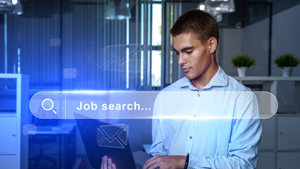 Obraz premium Young man conducting a job search in a modern office during the day while using a laptop