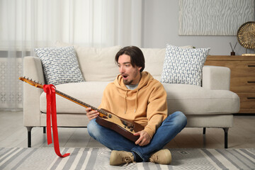 Dreams come true. Excited man with guitar at home