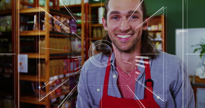Smiling shop employee wearing red apron stocking wooden shelves in shop, showing clipped microphone
