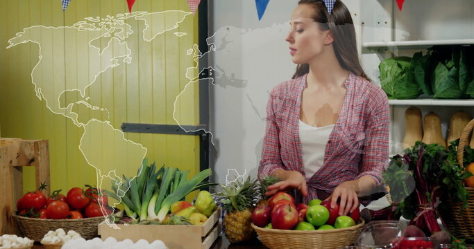 Produce vendor wearing red plaid shirt arranging fruits at market stall, with baskets of apples - Powered by Adobe