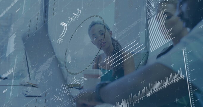 Analyzing colleagues reviewing data charts on glass wall at conference table, with laptops