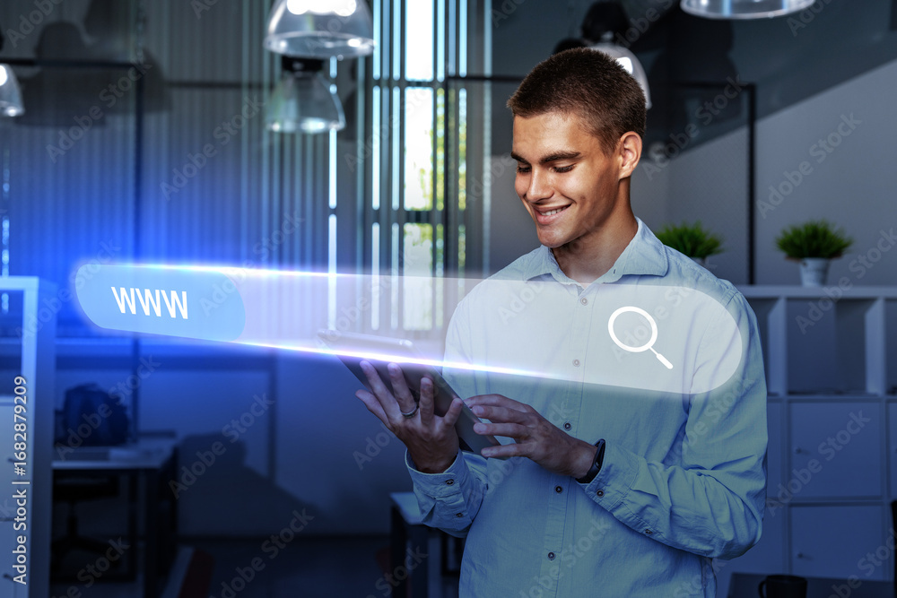 Poster man using tablet to browse online in modern office during daytime