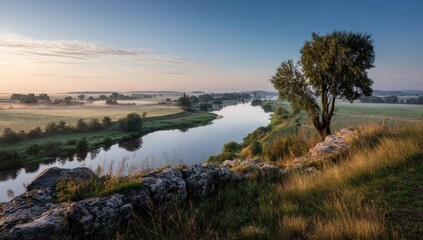 Obraz premium Panoramic view of a river winding through a misty landscape at sunrise
