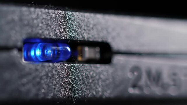 Close-up of a Glowing Blue LED Indicator Light on Dark Electronic Device