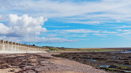 The beach at low tide opposite South Street and Victoria Park in Arbroath on a bright morning in Late August.