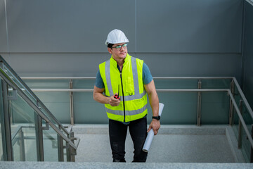 Construction engineer inspecting railway track industrial documents in hand while examining rail...