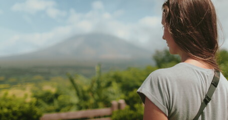 Woman enjoy view on Legazpi Mountains Volcano, Philippines. Asia wild nature tropical landscape. Tourist female relax, outdoor lifestyle travel on summer holiday vacation. Back view,