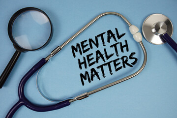 Mental Health Matters text with Stethoscope and magnifying glass on blue background